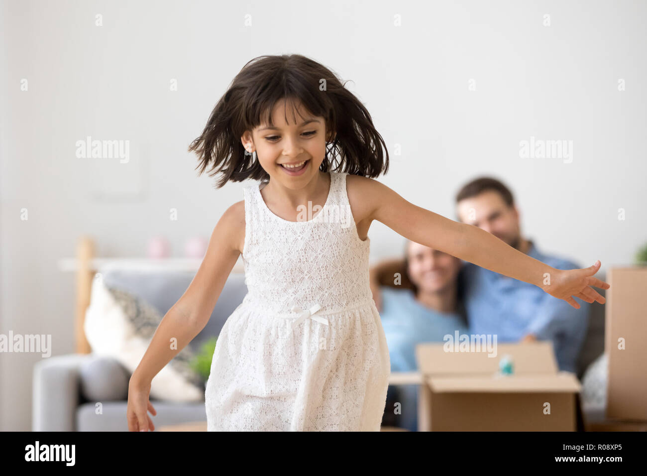 Cheerful girl running at new home at moving day Stock Photo