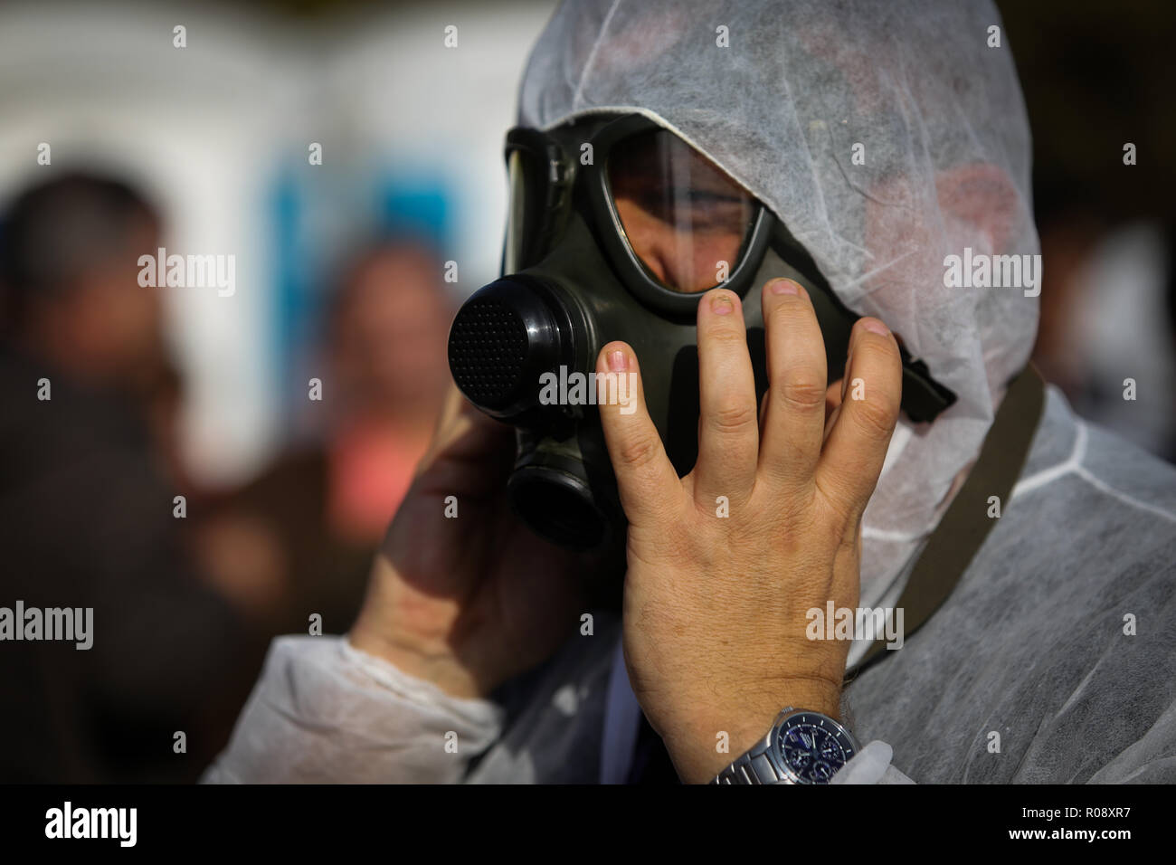 Vet doctor wearing a protective suit puts on a gas mask Stock Photo
