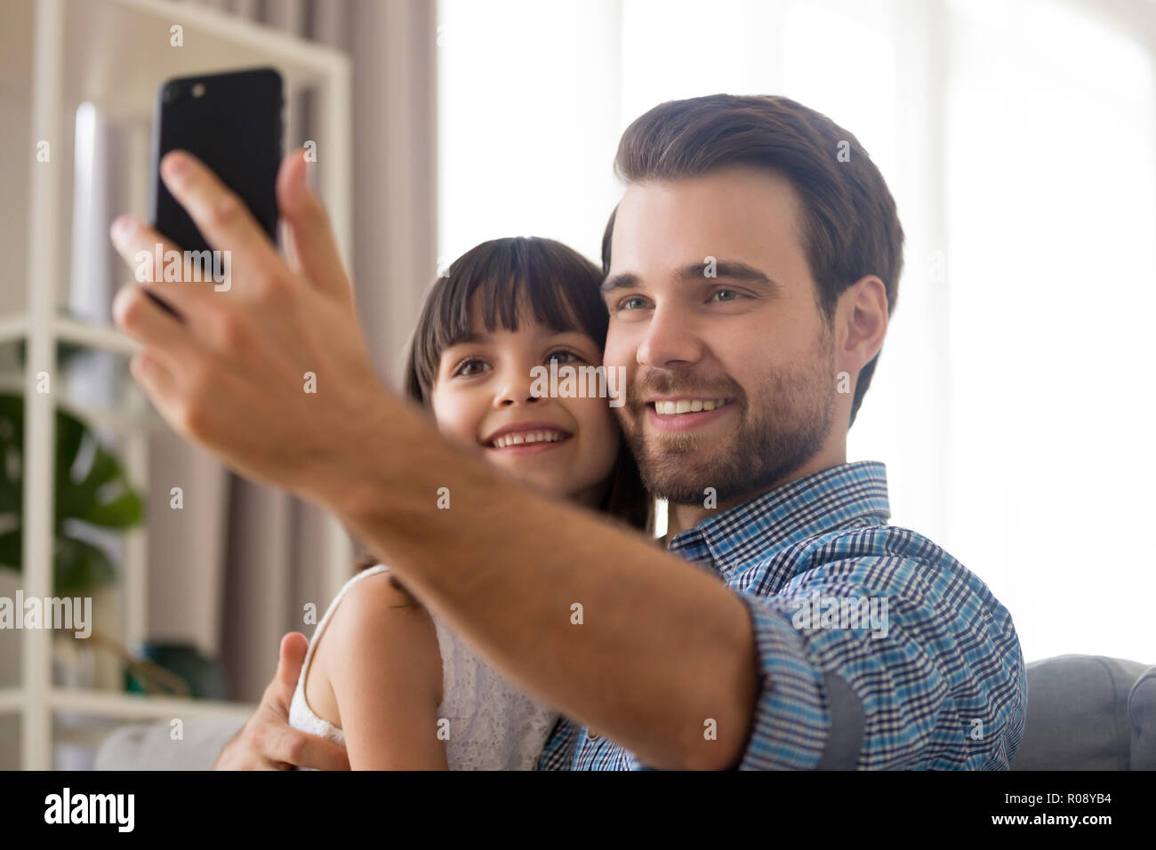Father and daughter using smartphone take selfie photography Stock Photo
