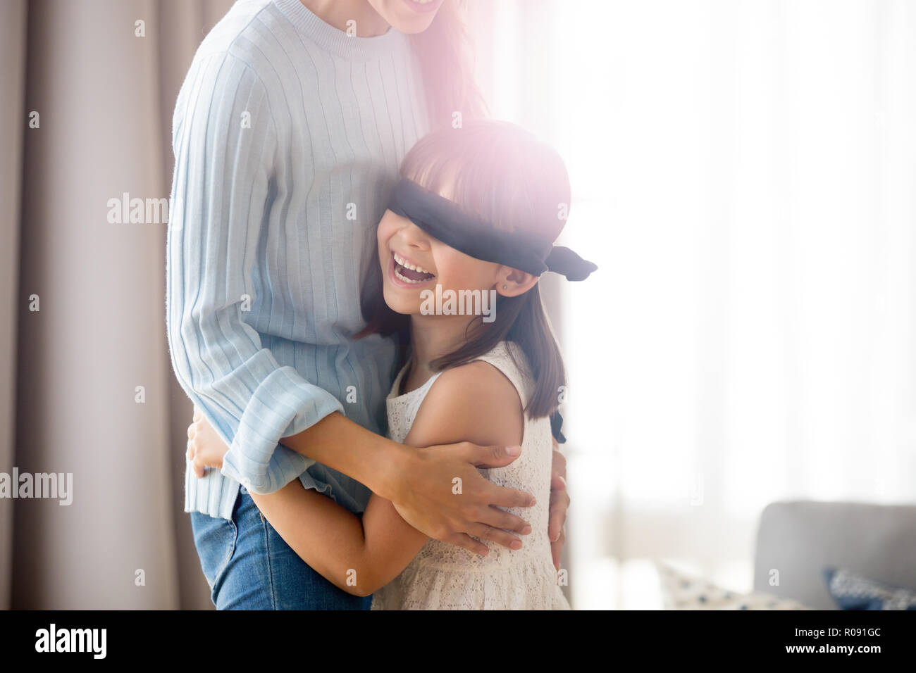 Family playing hide and seek at home, girl caught mother Stock Photo