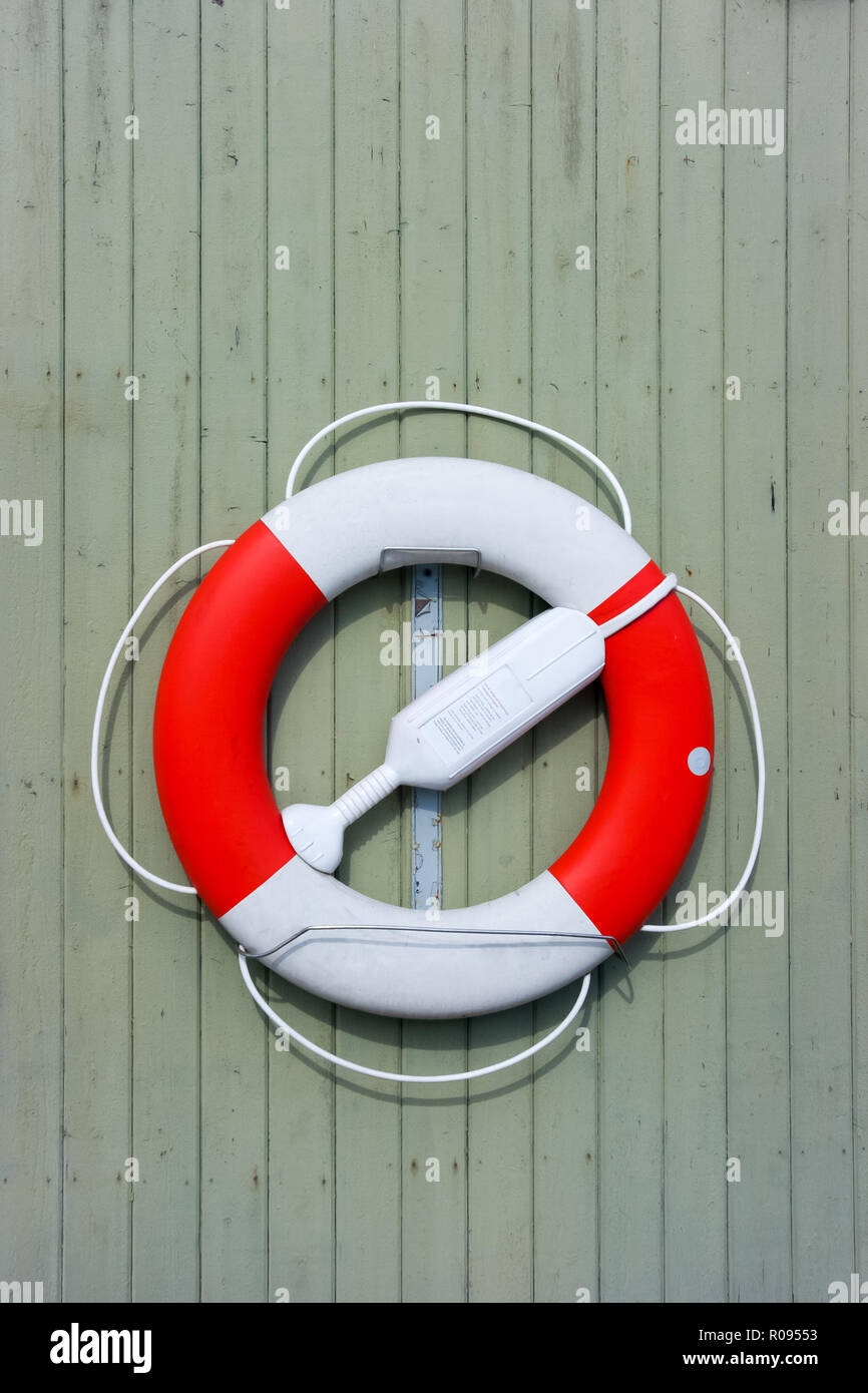 Plastic lIfe buoy hung on a water green wooden wall in Stockholm, Sweden, Europe Stock Photo