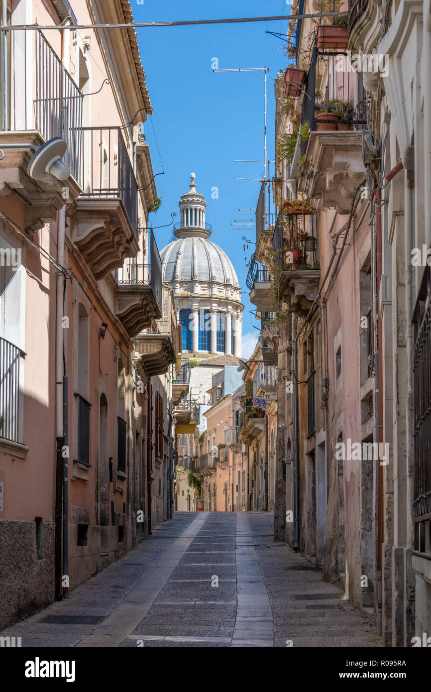 Narrow Street and Houses with Cathedral Dome Behind, Ragusa, Sicily Stock Photo