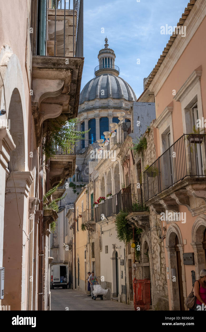 Narrow Street and Houses with Cathedral Dome Behind, Ragusa, Sicily Stock Photo