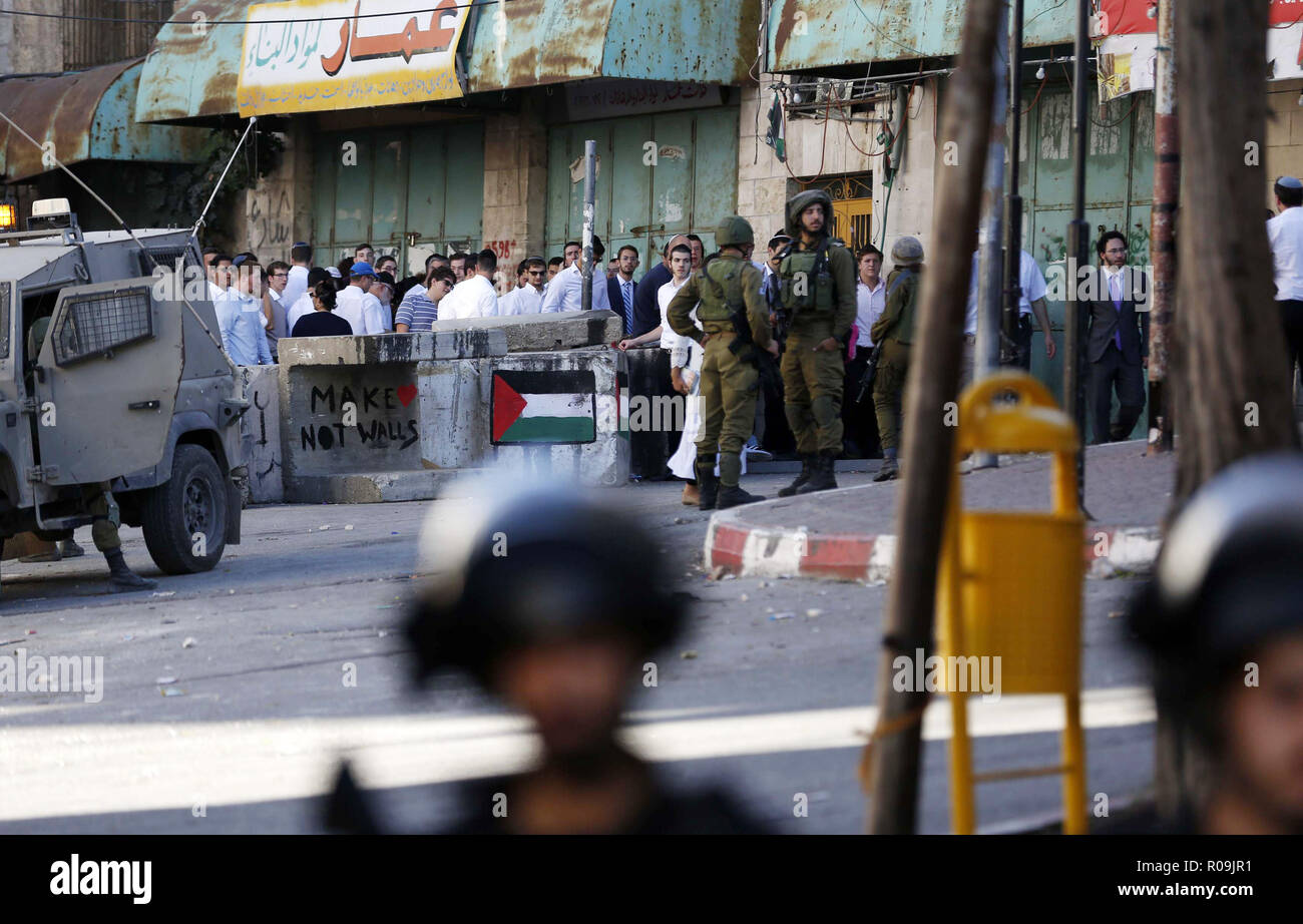 Hebron, West Bank, Palestinian Territory. 3rd Nov, 2018. Israeli soldiers stand guard as Jewish settlers celebrate Simchat Torah, a Jewish holiday that marks the conclusion of the annual cycle of public Torah readings, in the West Bank city of Hebron on November 3, 2018 Credit: Wisam Hashlamoun/APA Images/ZUMA Wire/Alamy Live News Stock Photo