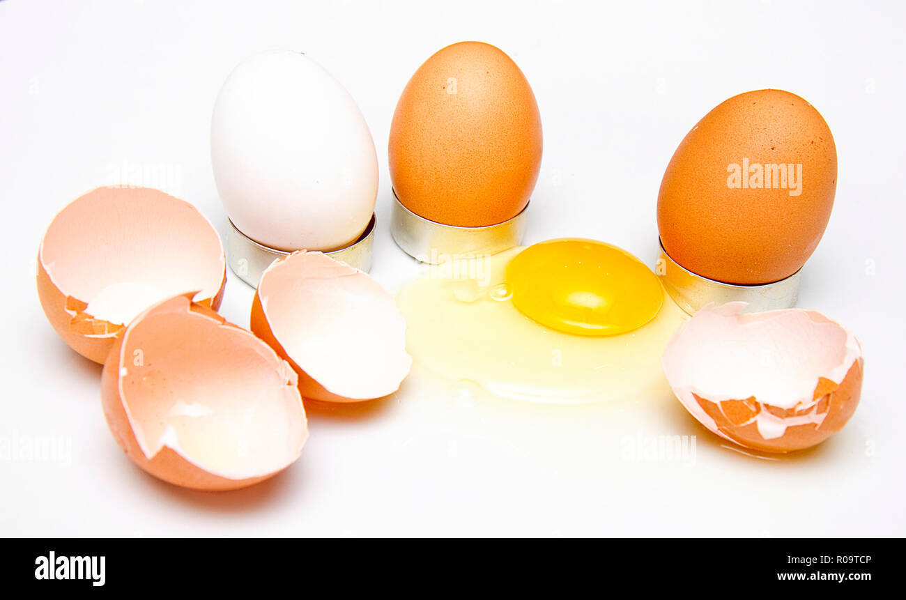 Concept image using brown and white eggs along with broken ones and yolk spilt .  Faces and affects added on some images.  Fun food images. Stock Photo