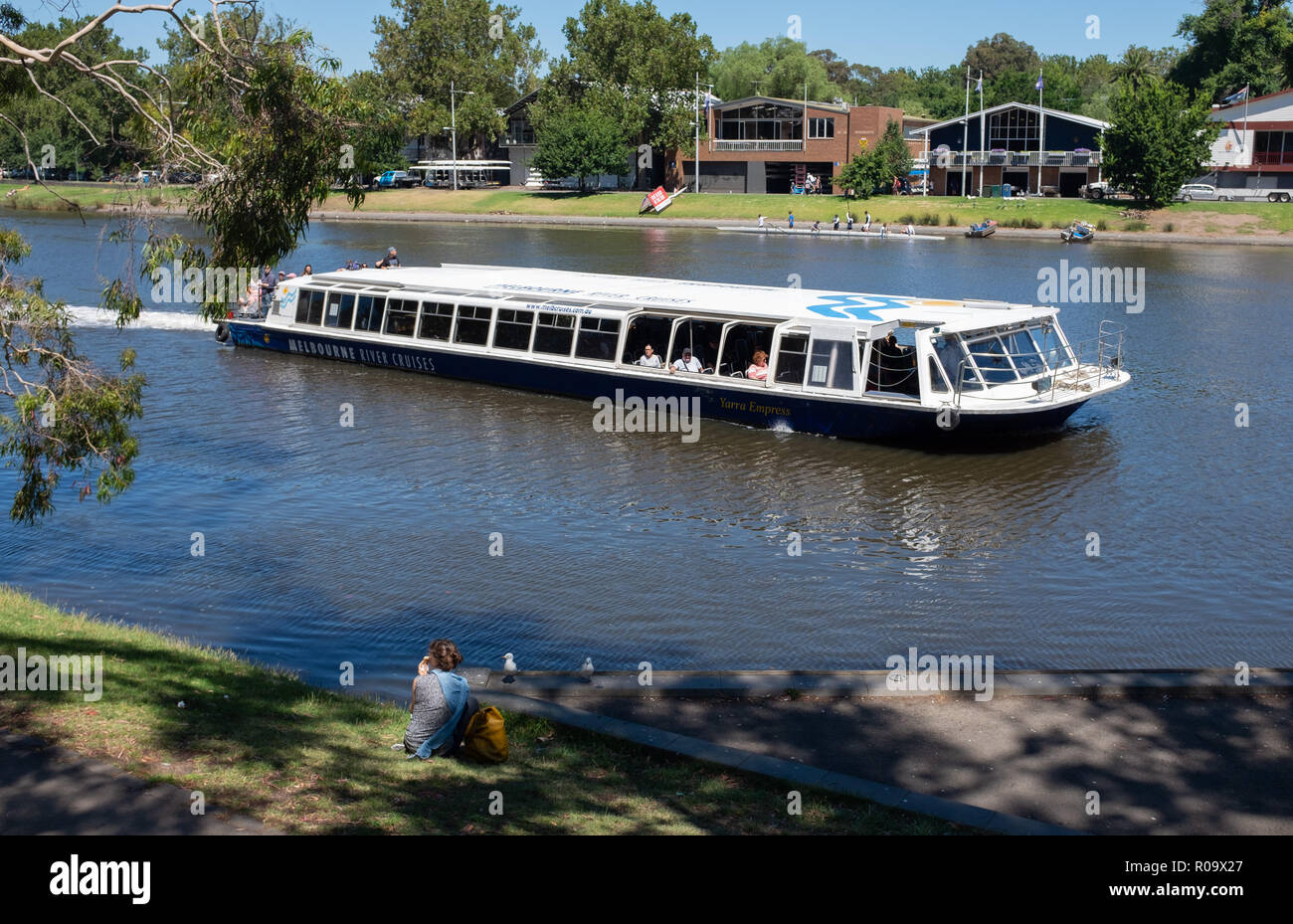 Sightseeing boat moving on Yarra river with historic rowing boathouses on the riverbank in Alexandra Gardens, Melbourne, Victoria, Australia Stock Photo
