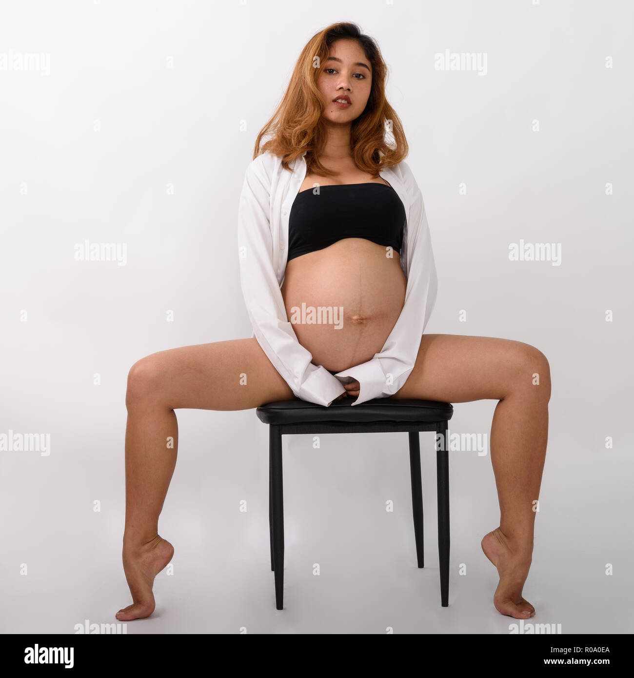 Portrait of beautiful young pregnant Asian woman sitting Stock Photo