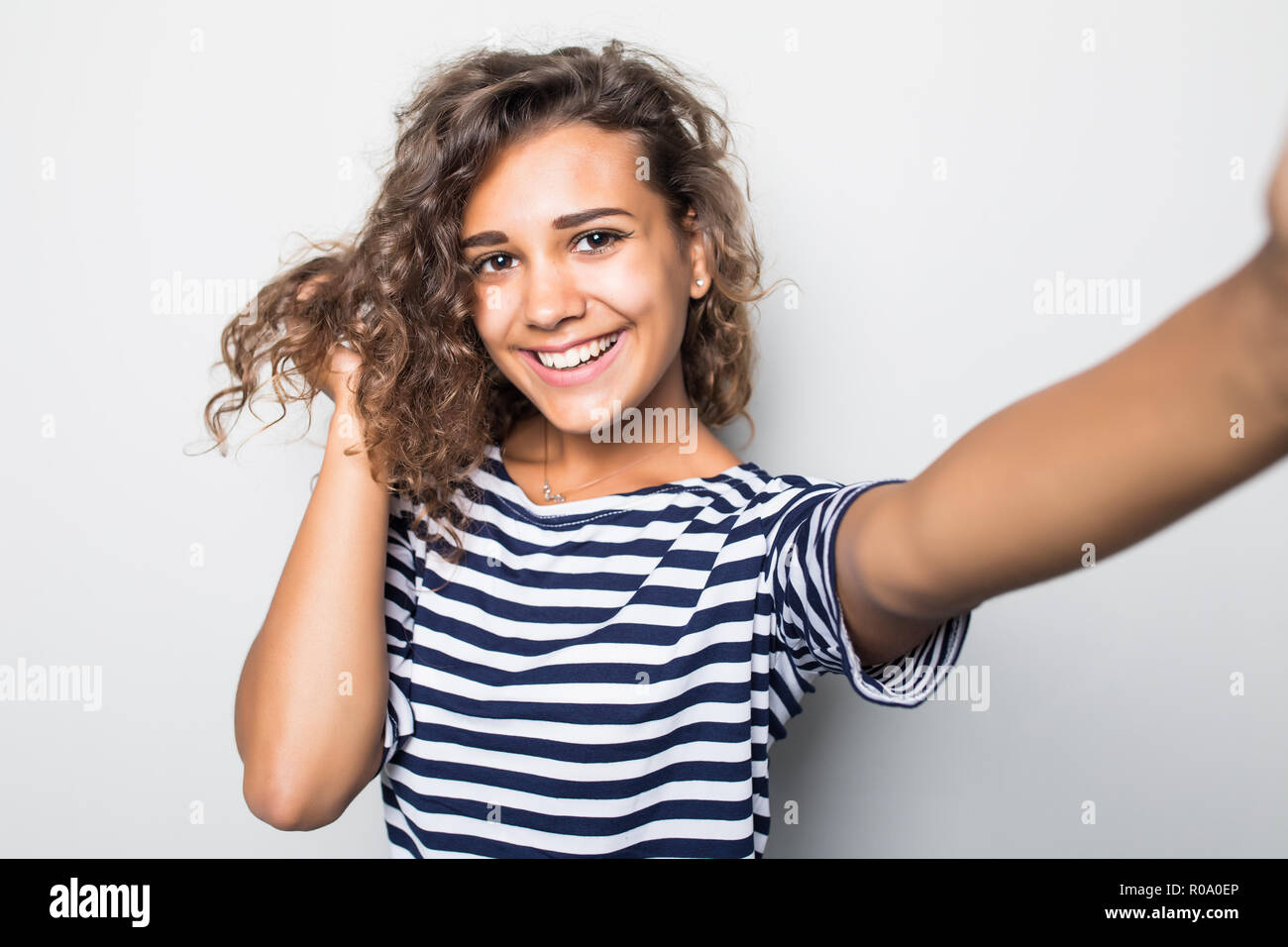 Close up portrait of a happy young woman making selfie against isolated ...