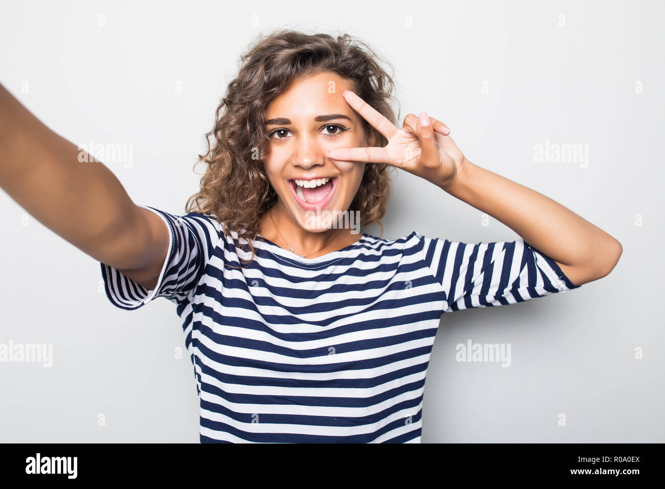 Close up portrait of a happy young woman making selfie against isolated ...