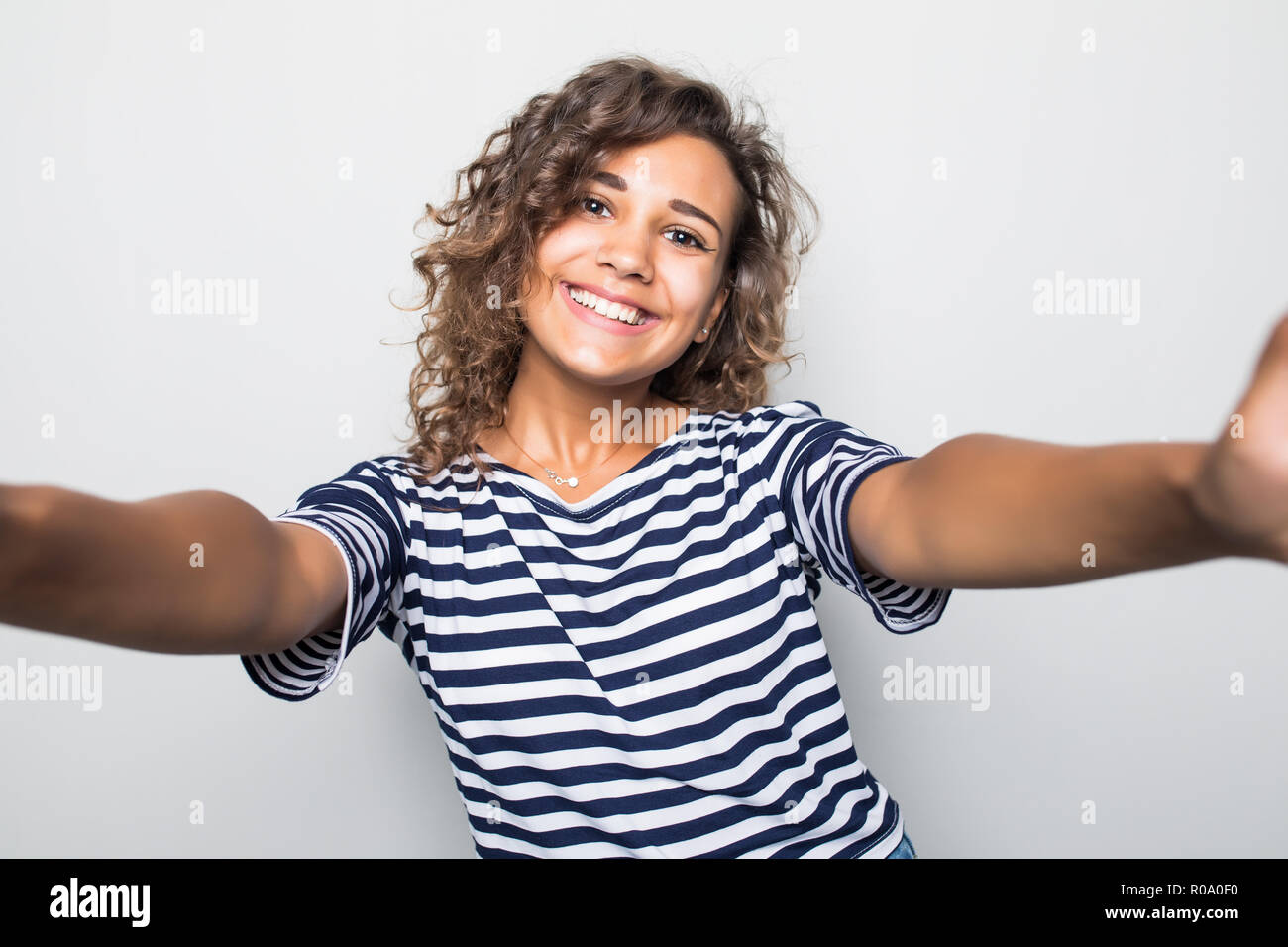 Close up portrait of a happy young woman making selfie against isolated ...