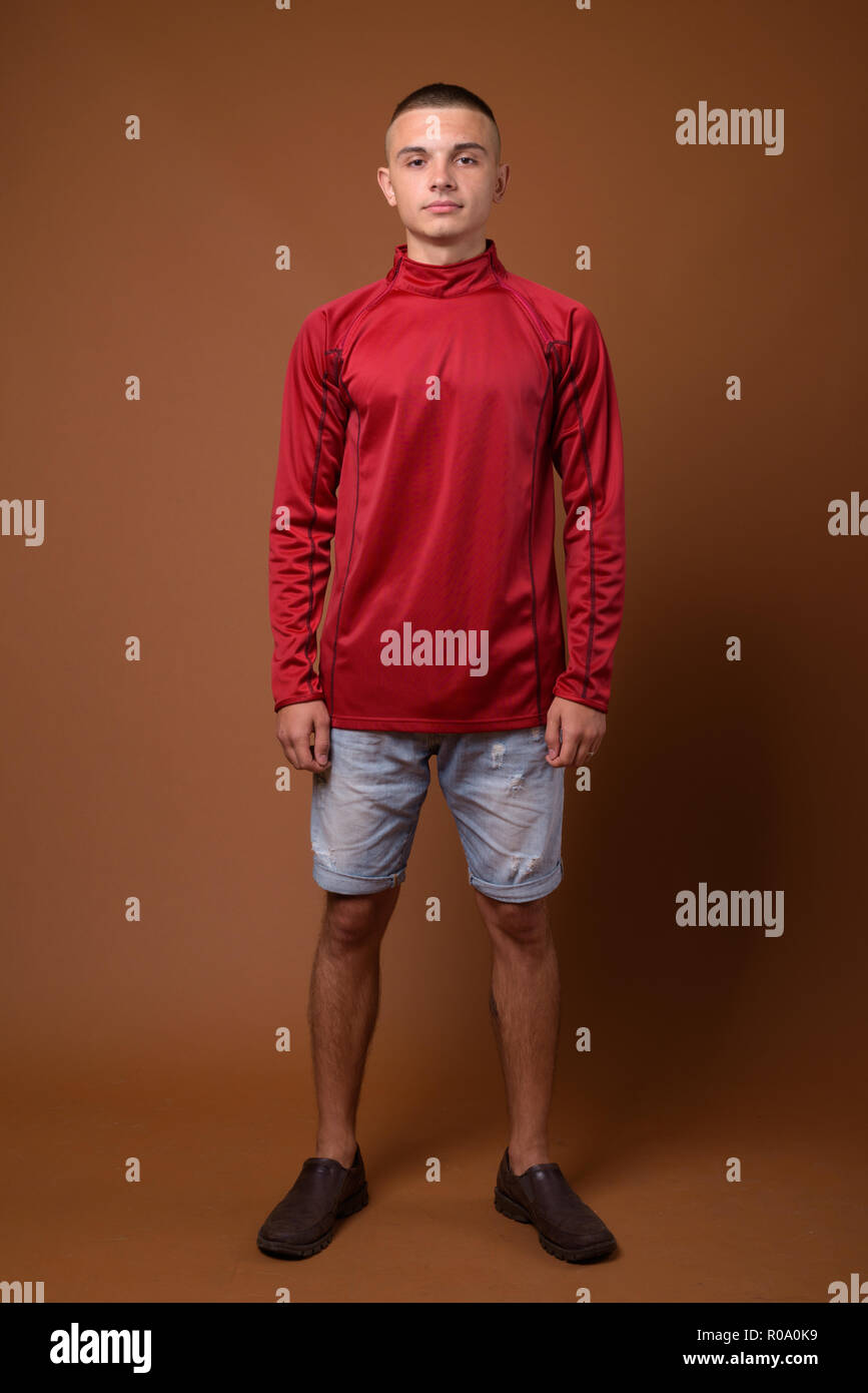 Studio shot of young handsome man with short hair against brown  Stock Photo