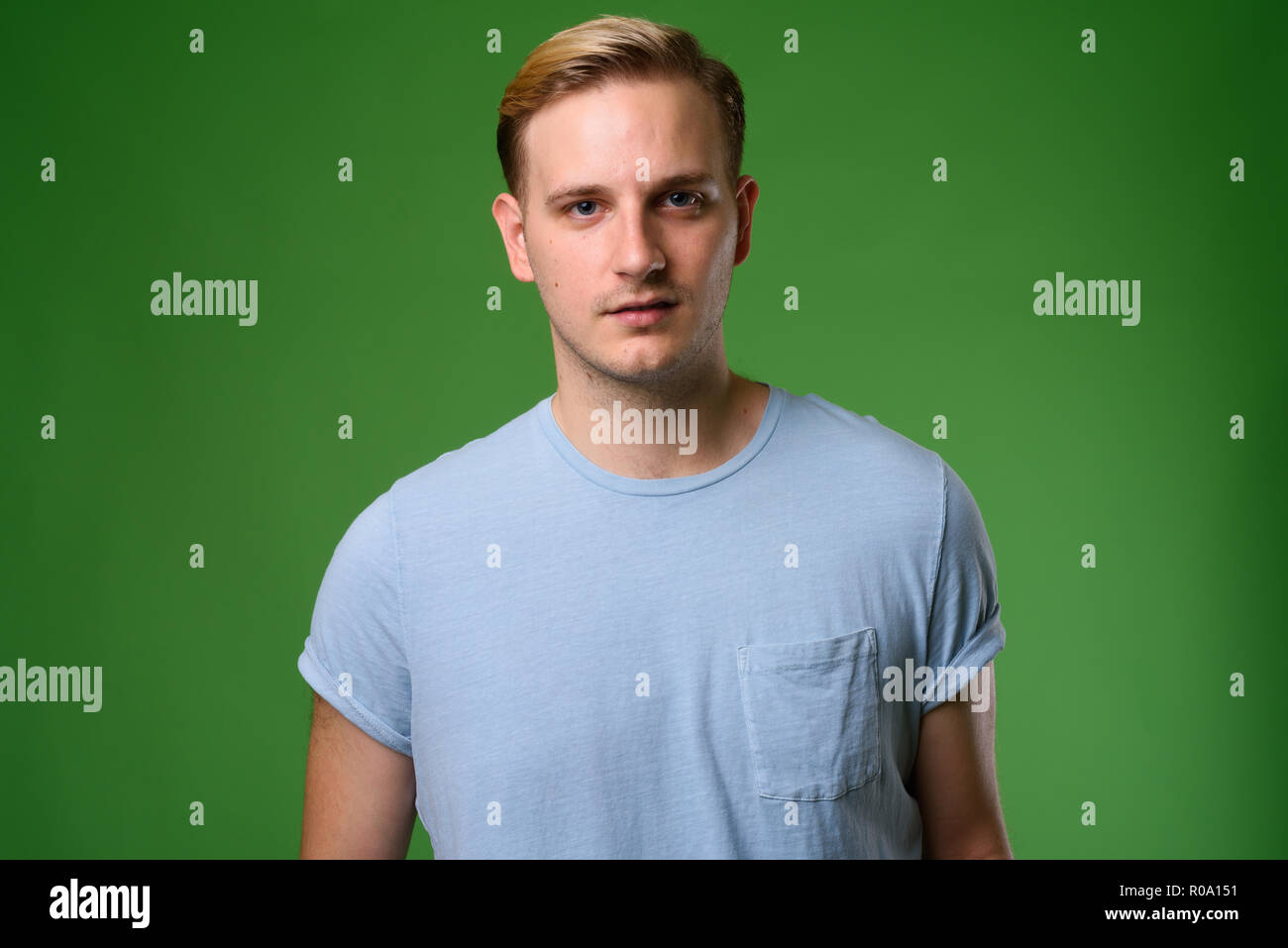 Young Handsome Man With Blond Hair Against Green Background Stock