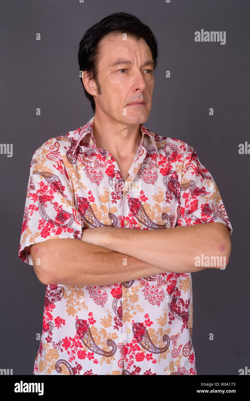 Mature handsome tourist man against gray background Stock Photo
