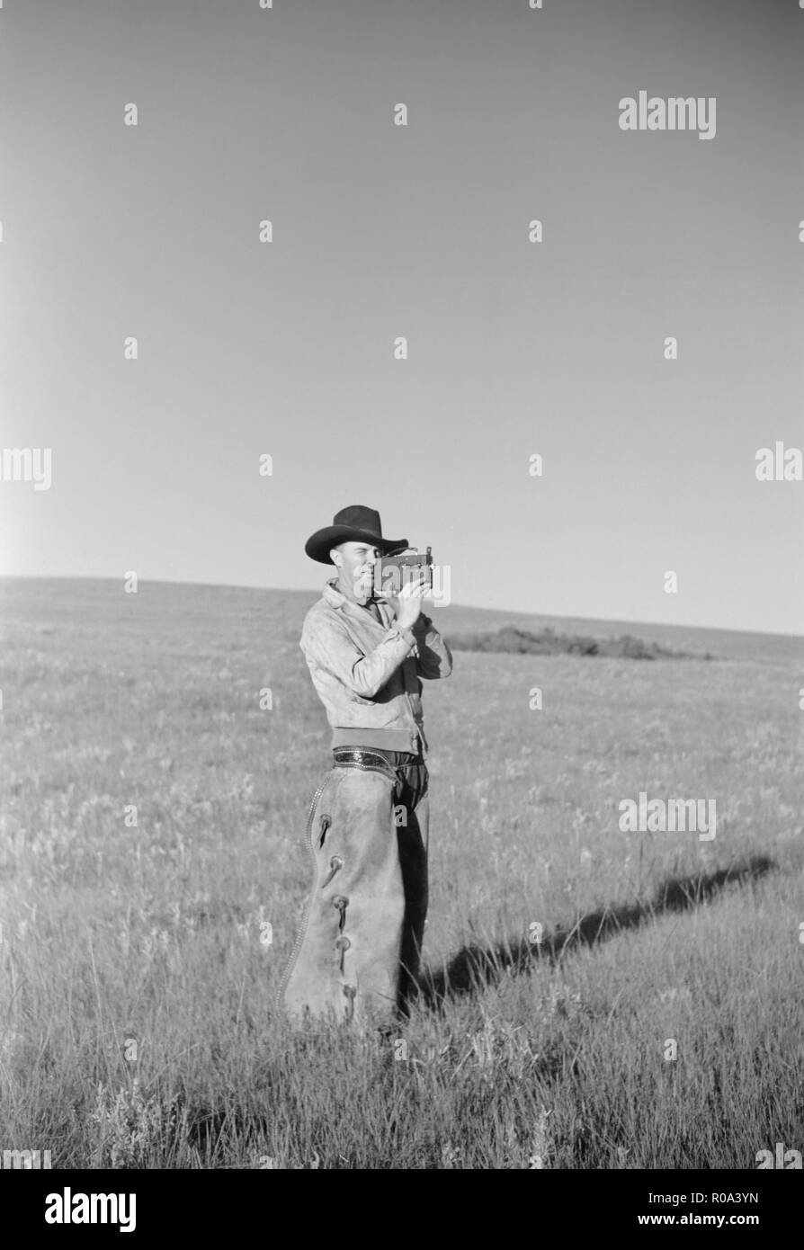 Cowboy with Amateur Movie Camera, Quarter Circle U Roundup, Montana, USA, Arthur Rothstein, Farm Security Administration, June 1939 Stock Photo