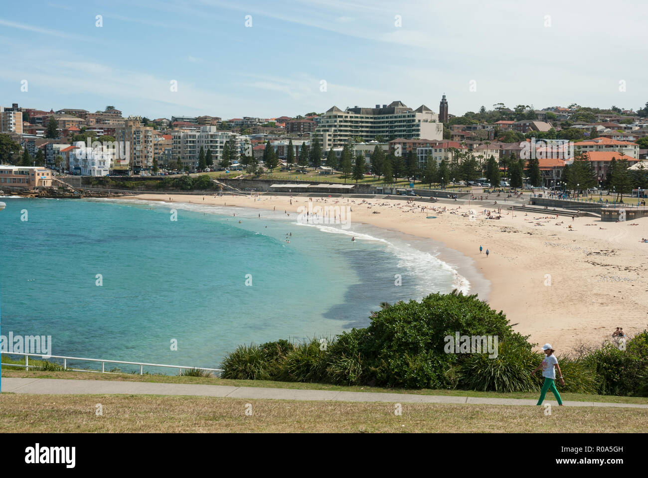 View along the bay of Coogee Beach, Sydney with golden sands, turquoise sea and in the distance people sunbathing and swimming. Stock Photo