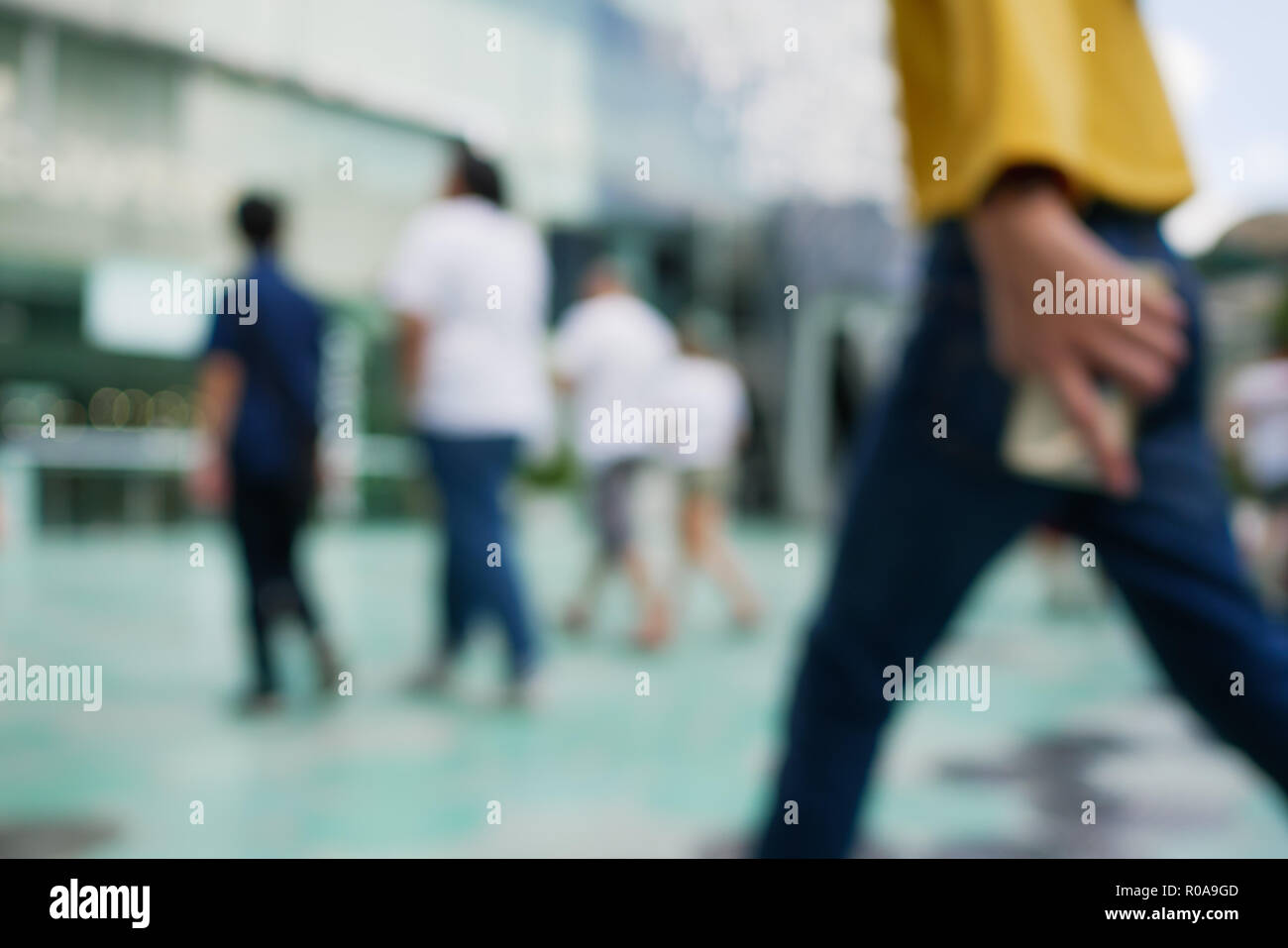 Blurry people walking with smartphone in hand Stock Photo