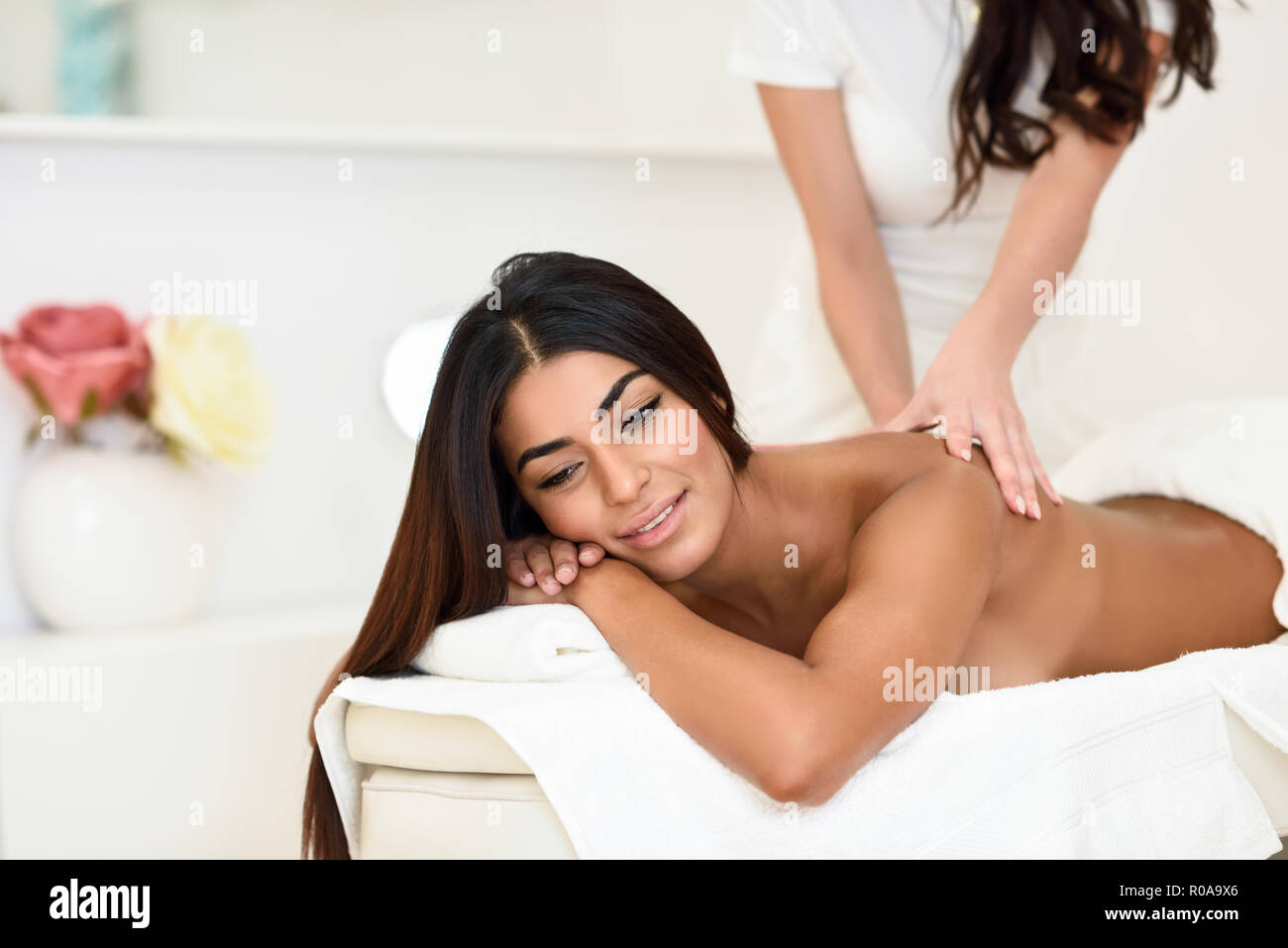 Arab woman receiving back massage in spa wellness center. Beauty and Aesthetic concepts. Stock Photo