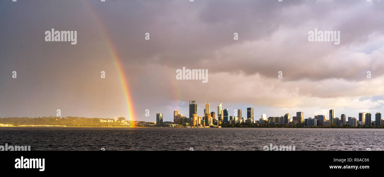 A rainbow over Perth city and the Swan River at sunrise. Stock Photo