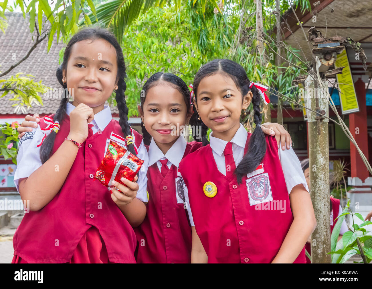 Indonesian smiling schoolgirls in uniform posing in front of their school Stock Photo