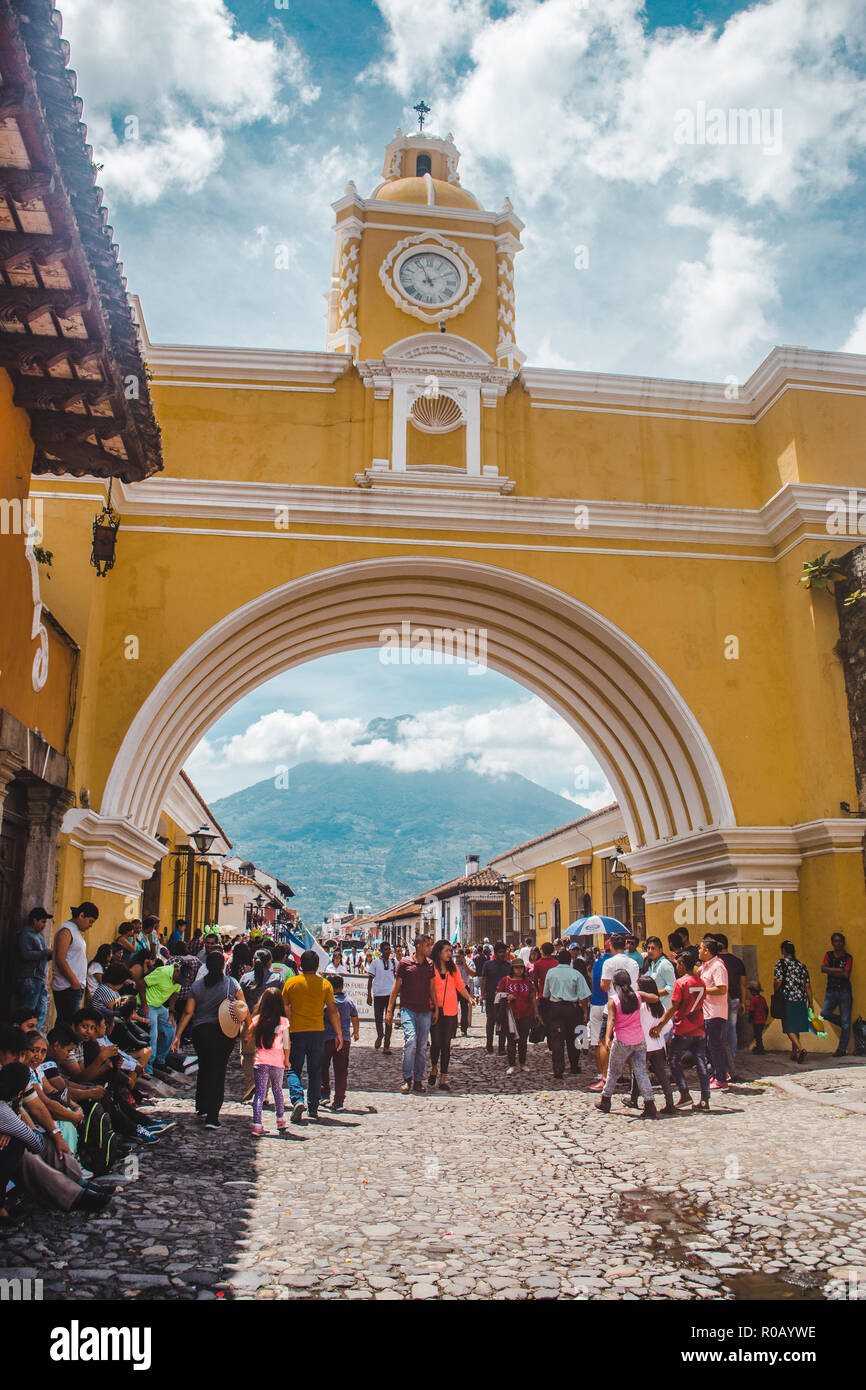 Crowds gathering to take pictures around the famous landmark yellow Arch of Santa Catalina in Antigua Guatemala Stock Photo