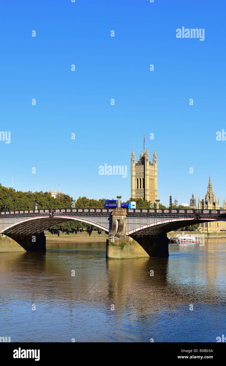 London, England, United Kingdom. A tour bus crosses the Lambeth Bridge over the River Thames. In the background at center right is Victoria Tower. Stock Photo