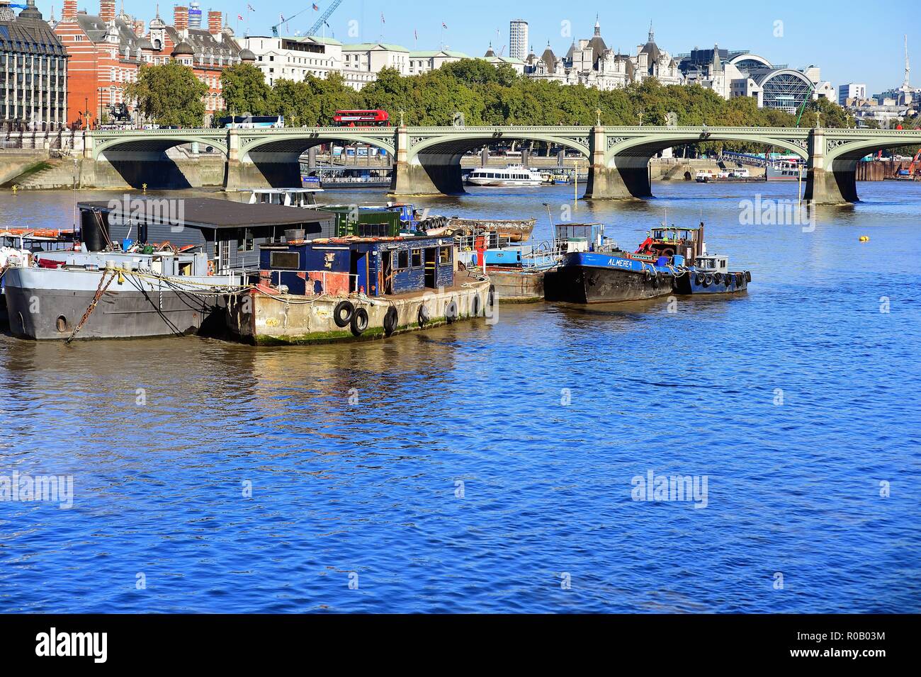 London, England, United Kingdom. Boats anchored on the River Thames provide a foreground for the Westminster Bridge beyond. Stock Photo