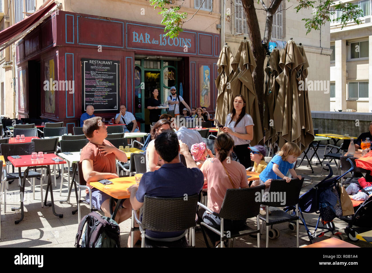 Diners seated in the spring sunshine outside the Bar des 13 Coins, a small  restaurant in Le Panier district of Marseille, France Stock Photo - Alamy