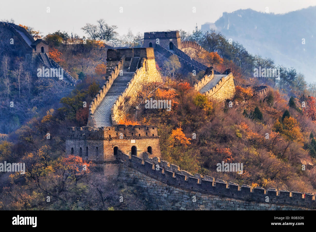 The Great Wall of China in a distant view with compressed towers and wall segments during autumn season in mountains near Beijing as ancient fortifica Stock Photo