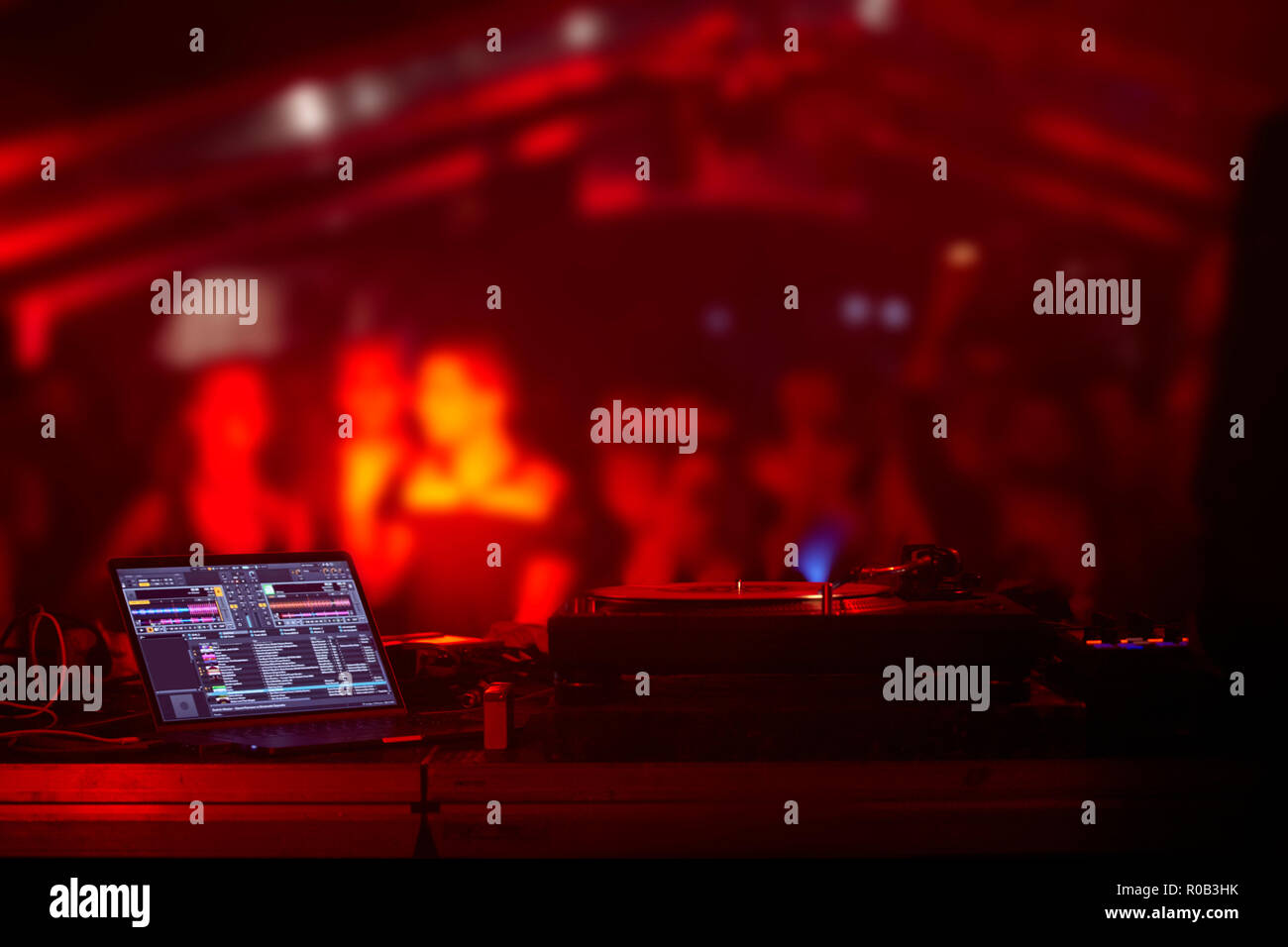 party, crown out of focus in background, dj equipment backstage, red colorful light Stock Photo