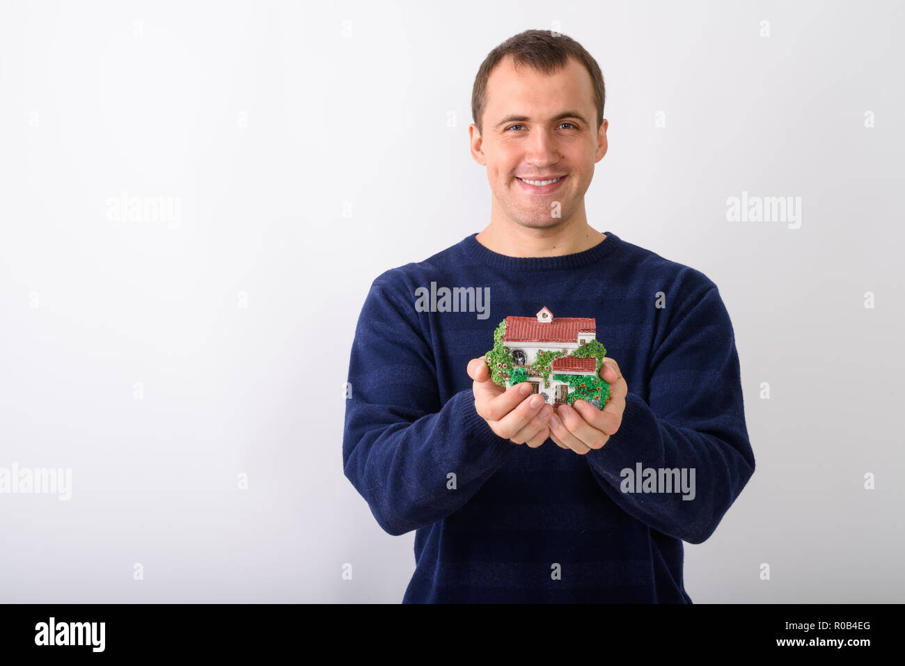 Studio shot of young happy muscular man smiling while holding ho Stock Photo
