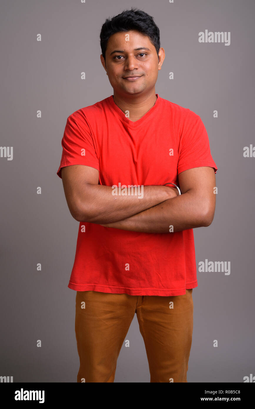 Portrait of young Indian man against gray background Stock Photo