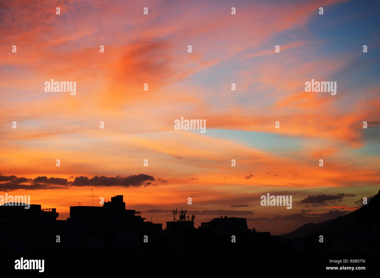 Beautiful sunrise in the city with blue and orange tones that blend together like brushstrokes in the sky Stock Photo