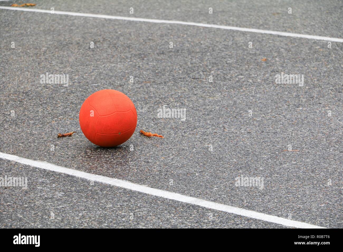 orange soccer ball on asphalt Stock Photo Alamy