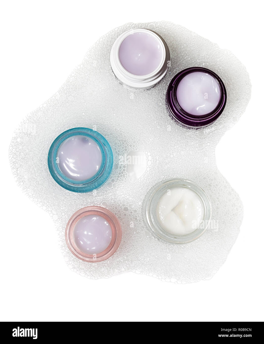 Various cosmetics in jars in soapsuds. Cosmetic concept. Stock Photo