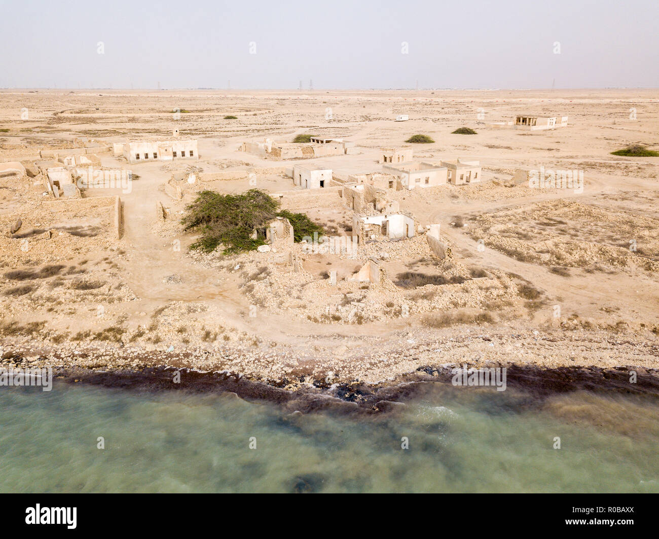 Ruined ancient old Arab pearling and fishing town Al Jumail, Qatar. The desert at coast of Persian Gulf. Abandoned mosque with minaret. Deserted town Stock Photo