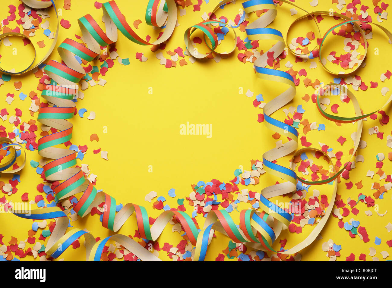 confetti and paper streamer frame on yellow background Stock Photo