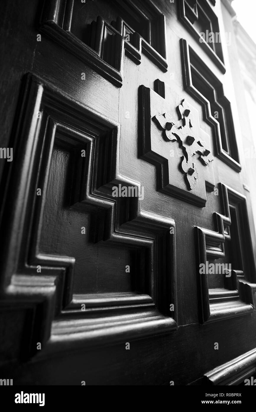 Detail of a vintage wooden door with geometric decorations and inlays. Stock Photo