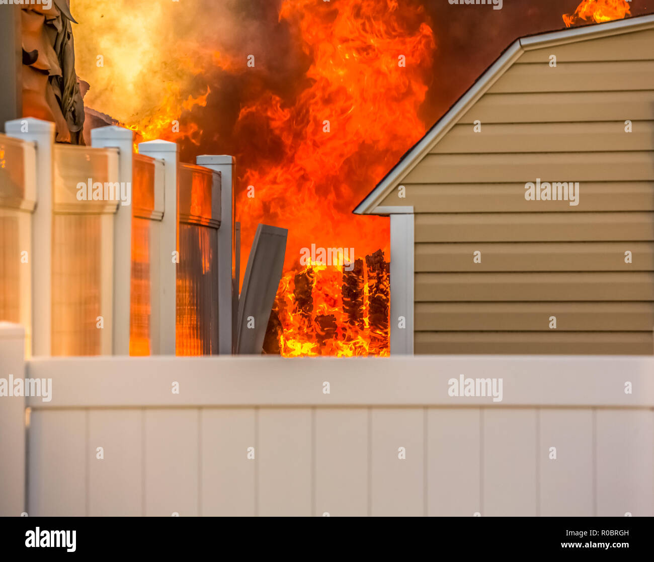 A backyard residential fire with blazing orange flames. Stock Photo
