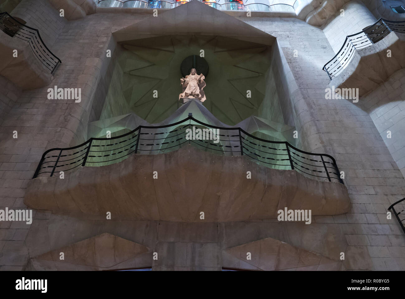 A religious female figure standing above a balcony inside the Sagrada