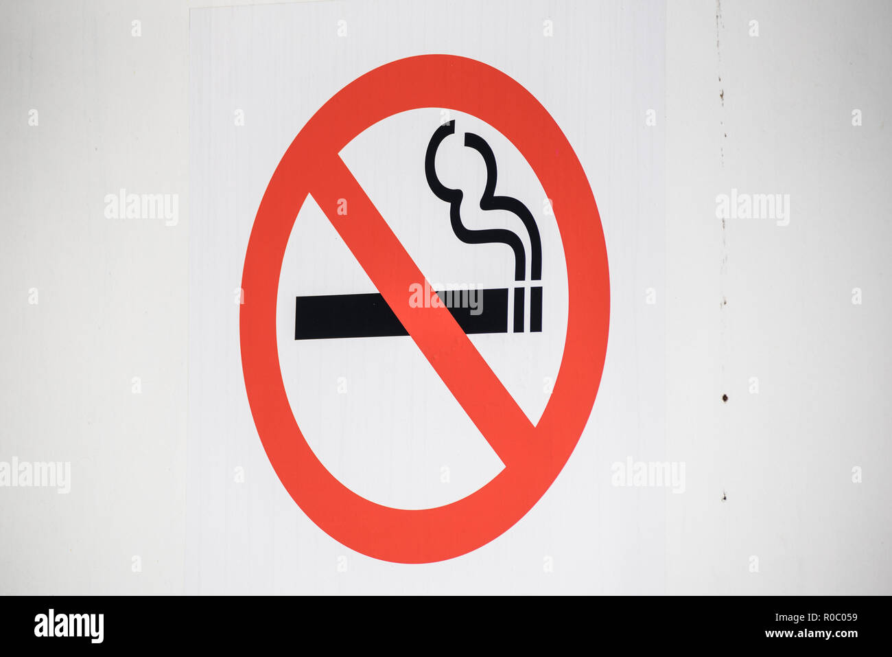 Smoking ban sign on white wall. Stock Photo