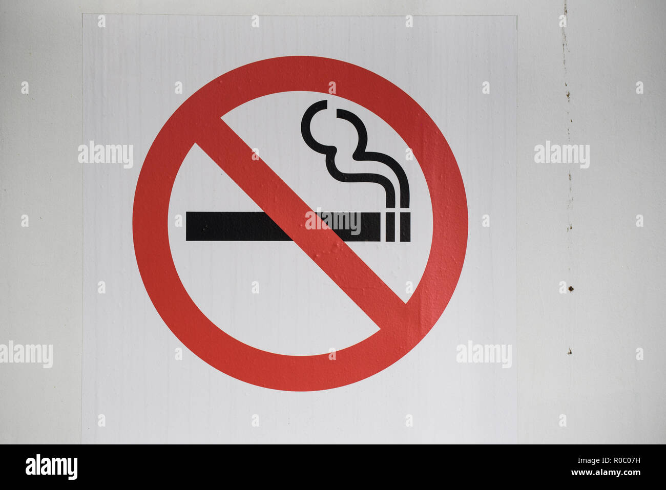 Smoking ban sign on white wall. Stock Photo