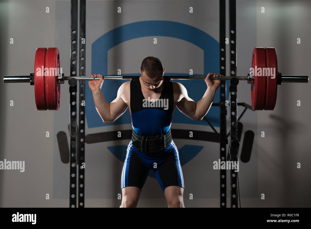 Powerlifter Working Out Legs With Barbell In A Gym Squat Exercise