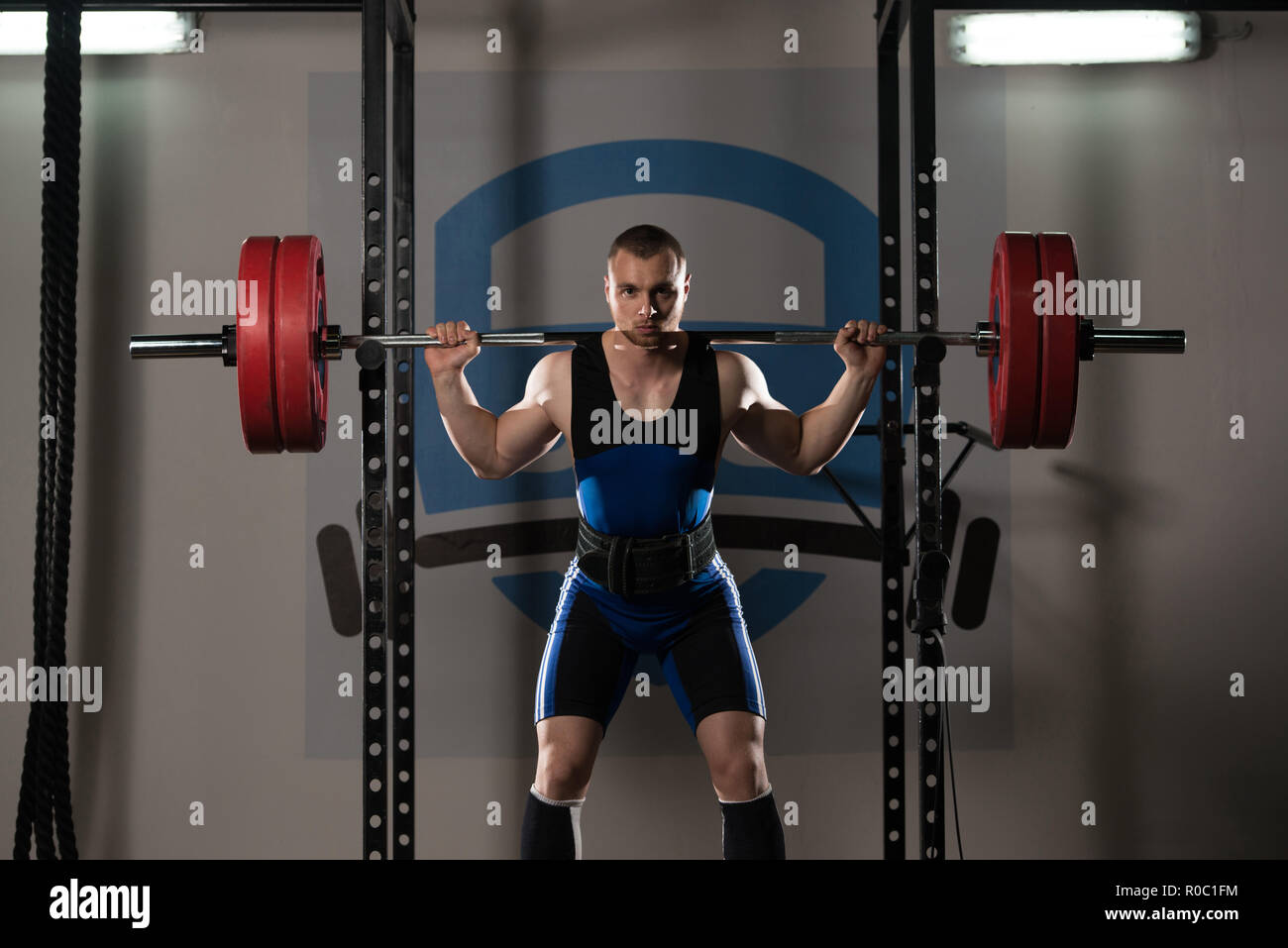 Powerlifter Working Out Legs With Barbell In A Gym Squat Exercise