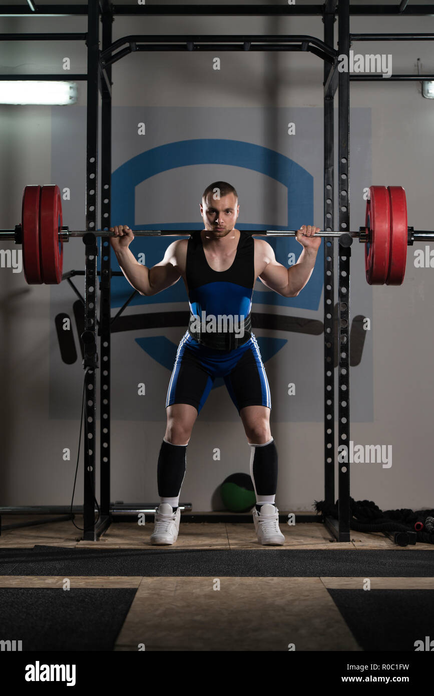 Healthy Powerlifter Man Working Out Legs With Barbell In A Gym - Squat  Exercise Stock Photo - Alamy