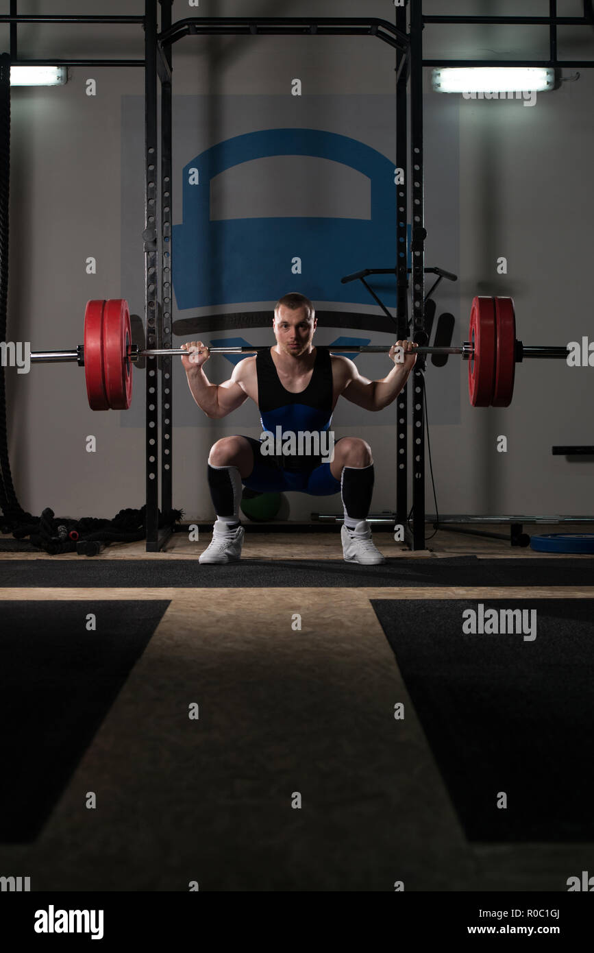 Powerlifter Working Out Legs With Barbell In A Gym Squat Exercise