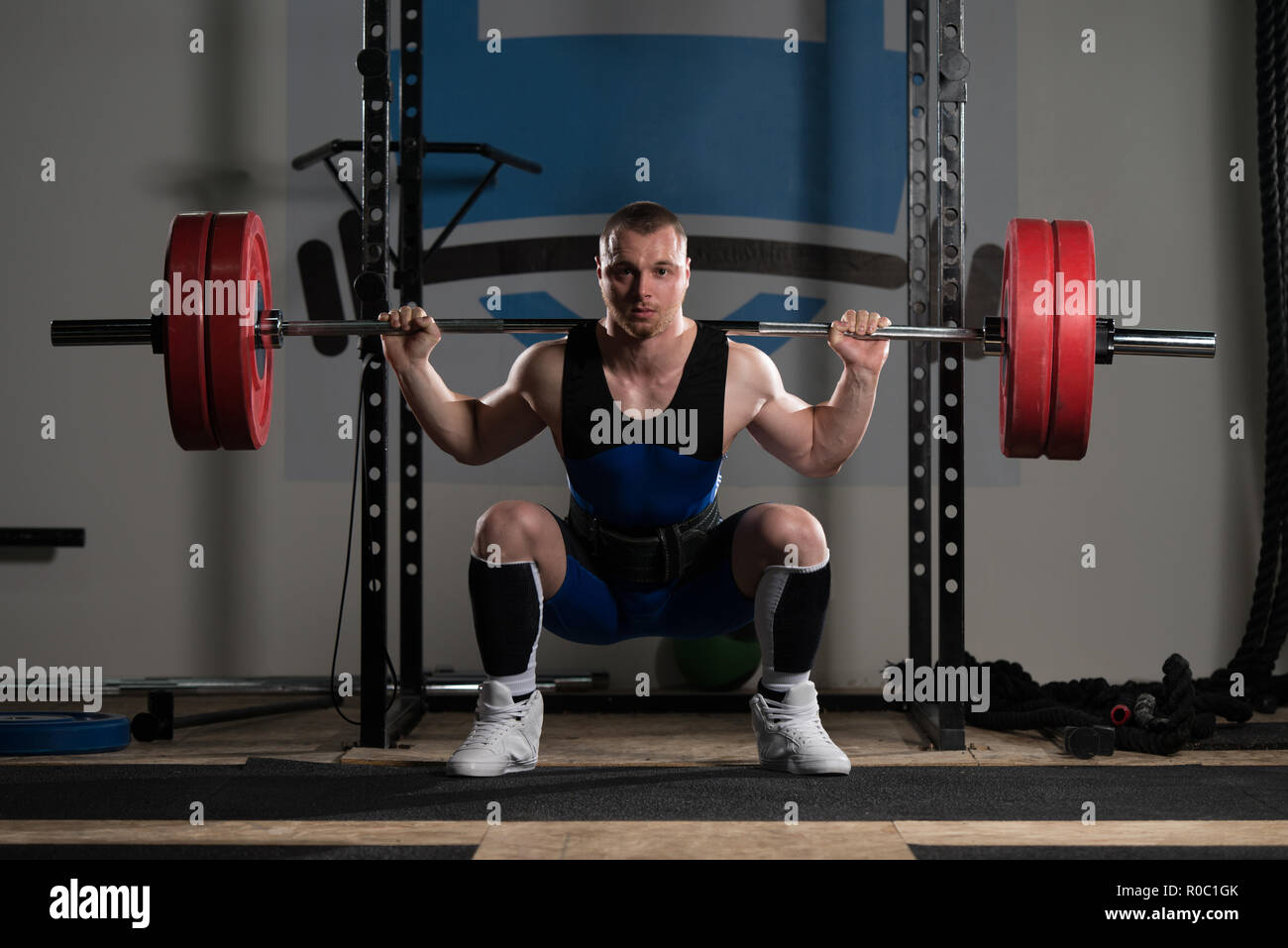 Healthy Powerlifter Man Working Out Legs With Barbell In A Gym Squat Exercise Stock Photo Alamy