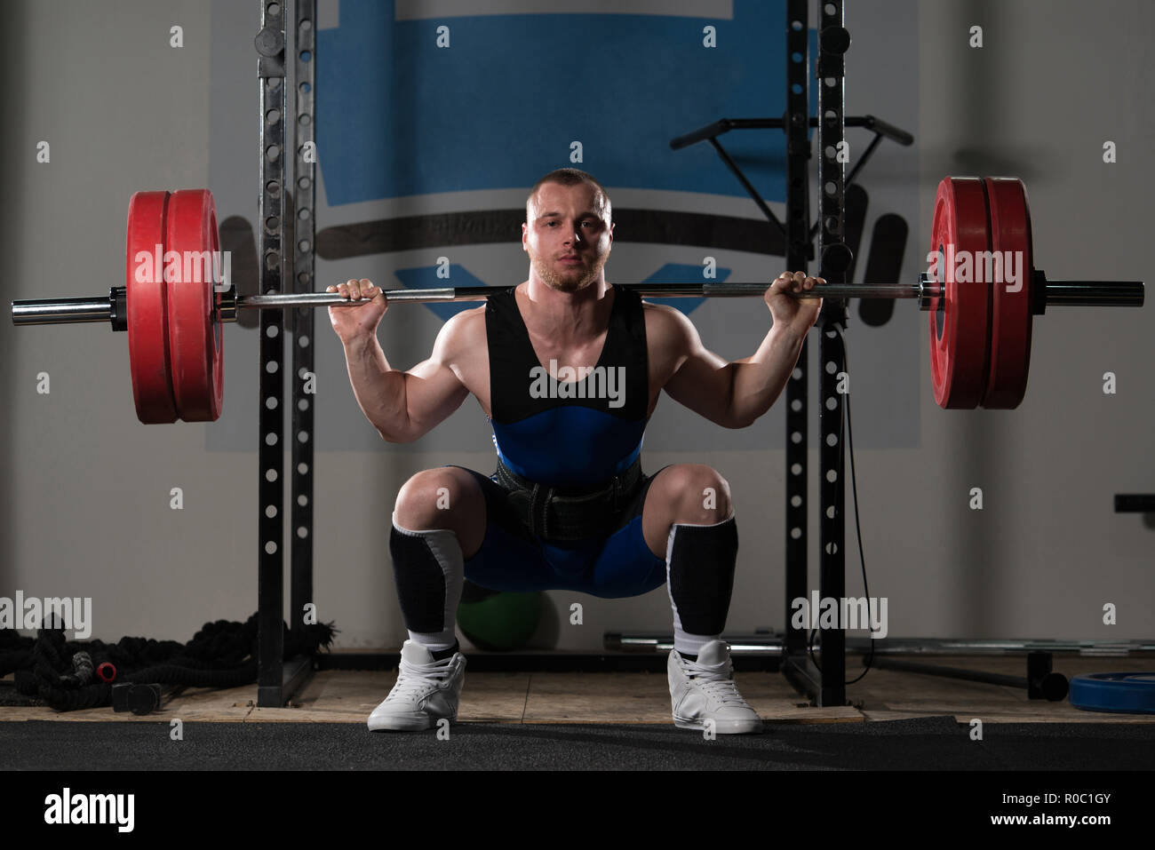 Powerlifter Working Out Legs With Barbell In A Gym Squat Exercise