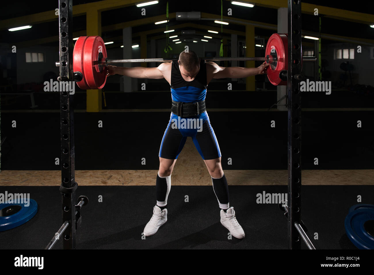 Healthy Powerlifter Man Working Out Legs With Barbell In A Gym Squat