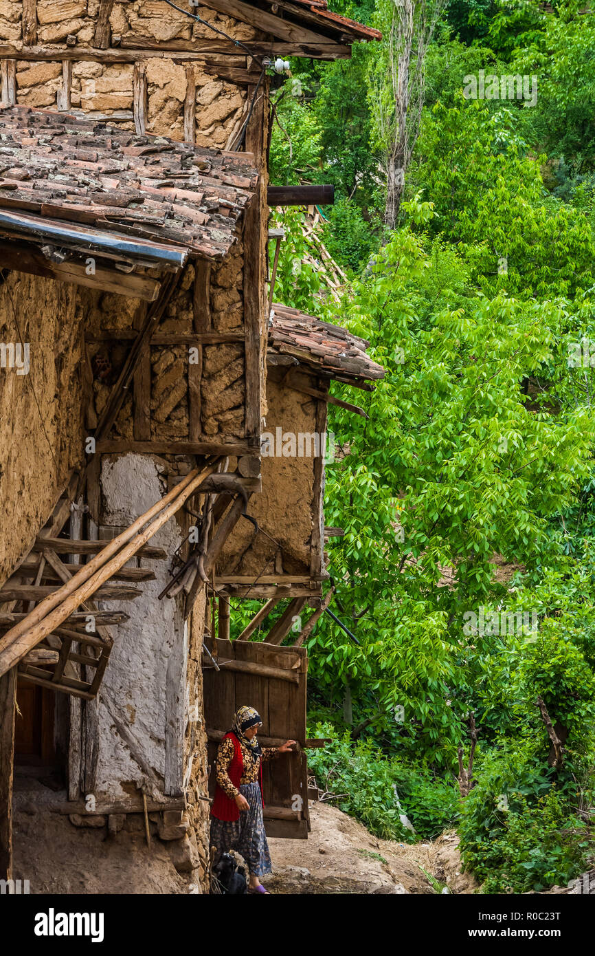 Iznik, Turkey, May 10, 2012: Woman emerging from a traditional house in the village of Tacir. Stock Photo