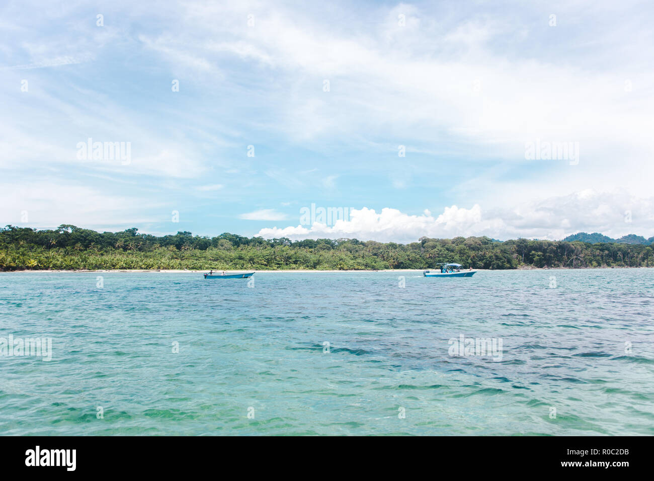 Two blue fishing boats off the jungley Caribbean coast of Cahuita, Costa Rica Stock Photo